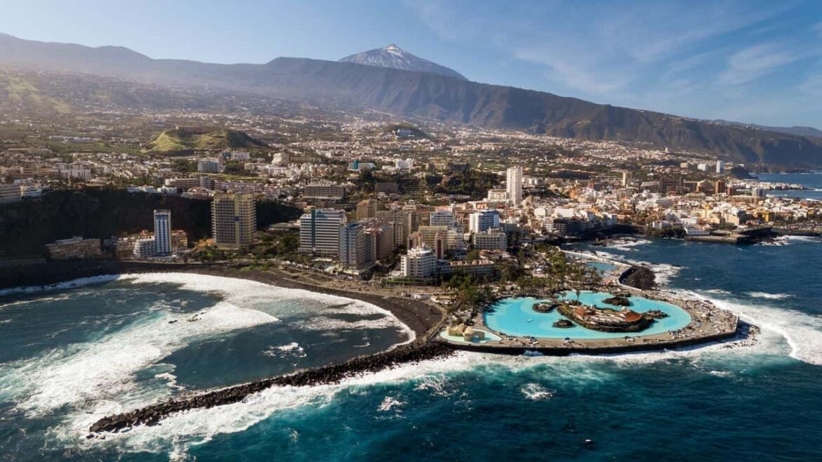 Vue aérienne de Puerto de la Cruz avec le complexe de piscines Lago Martiánez en bord de mer et le volcan Teide en arrière-plan à Tenerife, une destination idéale pour un voyage en mer.
